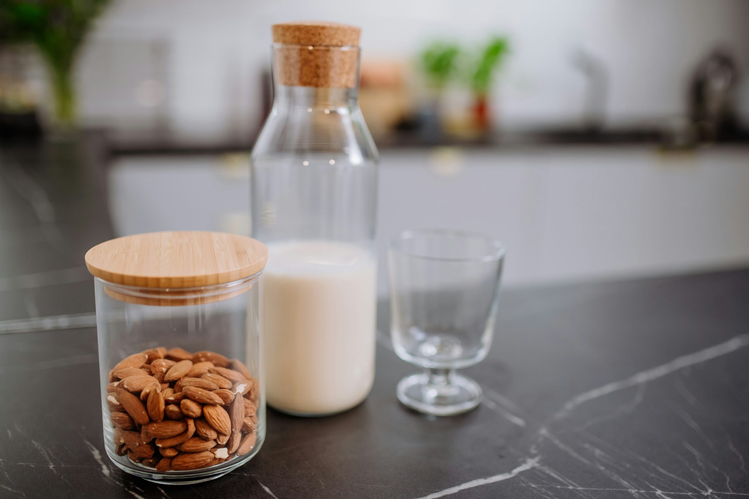 Various types of plant-based milk poured in glasses showing different textures and colors